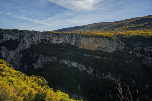 A vertical shot of the hiking area Sentier Blanc-Martel with trees in autumn
