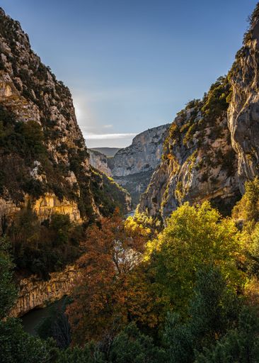 A vertical shot of the hiking area Sentier Blanc-Martel with colorful trees under the clear sky in autumn