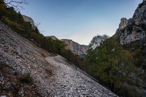 A scenic view of the hiking area Sentier Blanc-Martel with trees under the blue sky in autumn