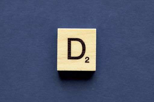 the letter D on a wooden cube from a wordplay board game