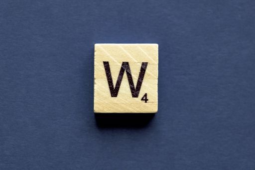 the letter W on a wooden cube from a wordplay board game