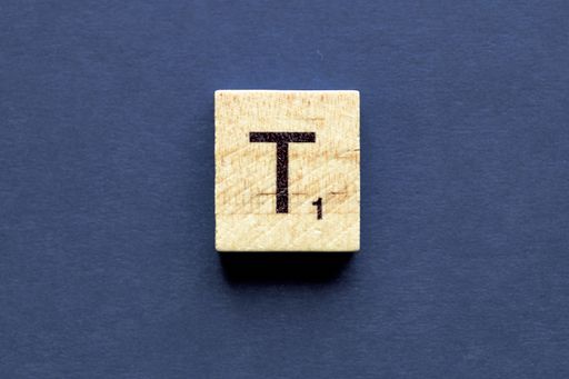The letter T on a wooden cube from a wordplay board game