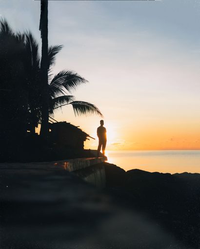 A  silhouette of male standing in beach during sunset