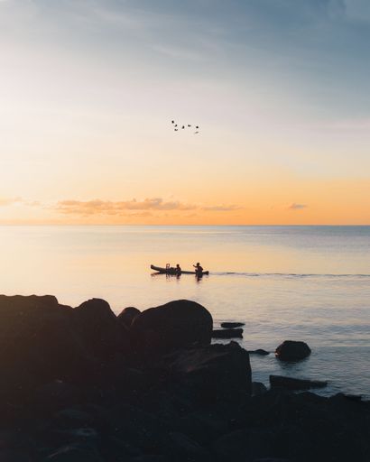 An aerial view of boat floating in sea during sunset