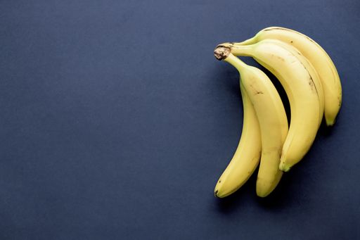An overhead shot of bananas on a blue surface - great for background or blog