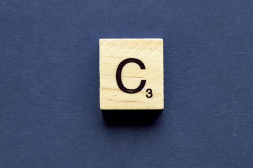 The letter C on a wooden cube from a wordplay board game