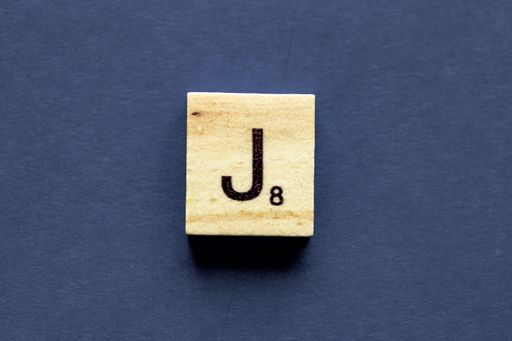 The letter J on a wooden cube from a wordplay board game