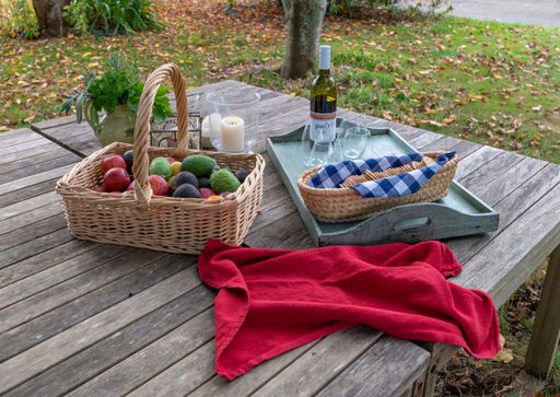 A picnic table with wine, fresh fruits and crackers