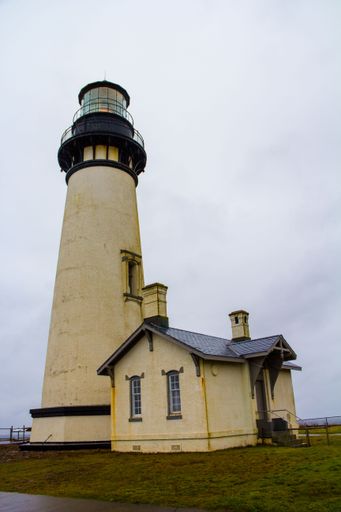A low-angle shot of a Yaquina Head Lighthouse under the cloudy sky in Newport Oregon.