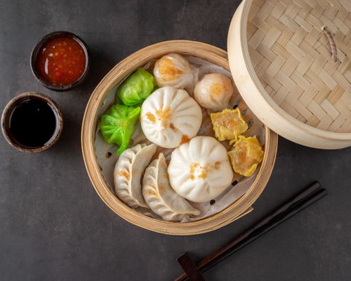 A top view of delicious Japanese dumplings in a bowl on the table with chopsticks and sauces on it