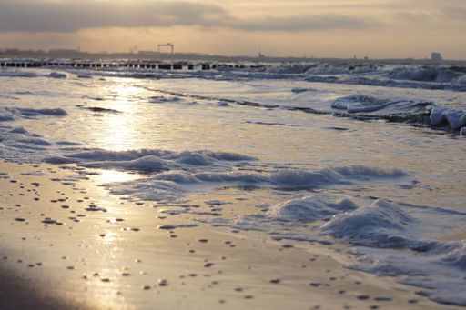 A landscape of the sea waves under the sunlight during the sunrise with a blurry background