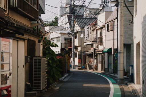 A horizontal image of a quiet Japanese street with buildings faceing each other in Tokyo