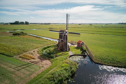 An aerial view of a mill in the meadow in the Netherlands