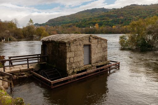 A high angle shot of a smal house on a pier near a river