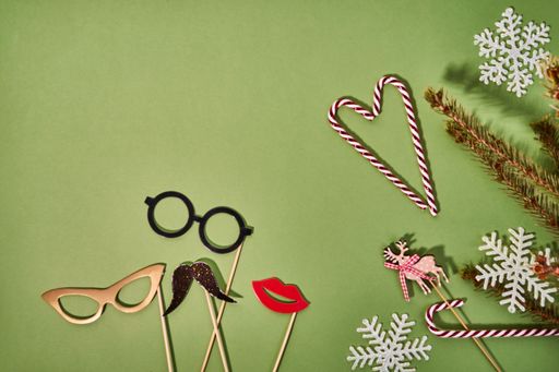 A top view of candy cranes and booth props for Christmas on a green surface