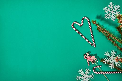 Top view of candy cranes and booth props for Christmas on a green surface
