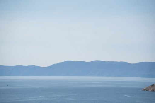 A beautiful lake with high hills against the clear sky in the background in Croatia, Bakar