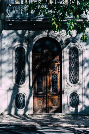 A vertical shot of vintage wooden doors of an old gray stone building.