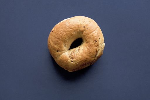 A closeup shot of a doughnut on a dark blue surface