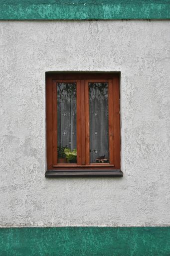 A vertical shot of the closed windows of a building at daylight