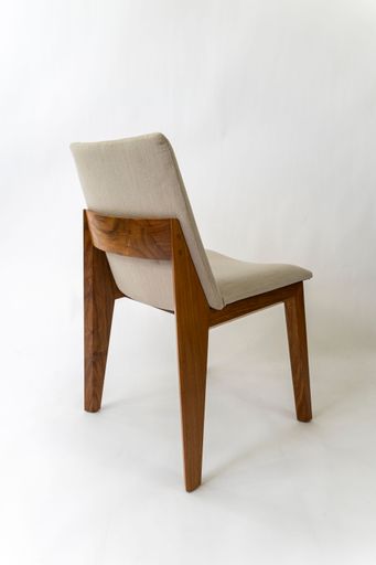 A vertical shot of a wooden chair, with a beige seat cushion isolated on a white background
