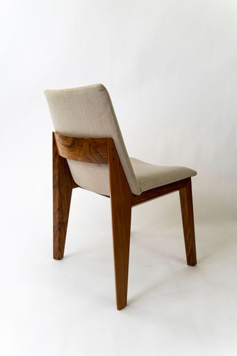 A vertical of a cozy chair with a soft sit and beautiful wooden legs isolated on a white background