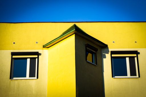A low angle shot of a yellow building under the blue sky