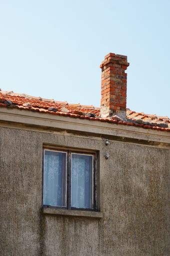 A vertical shot of an old house with a chimney