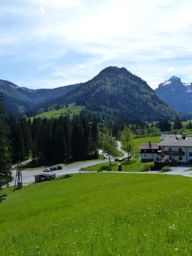 A vertical shot of a rural village with mountains near the Austrian alps