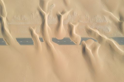 A closeup shot of roads of unfinished construction covered by the desert sands in the United Arab Emirates