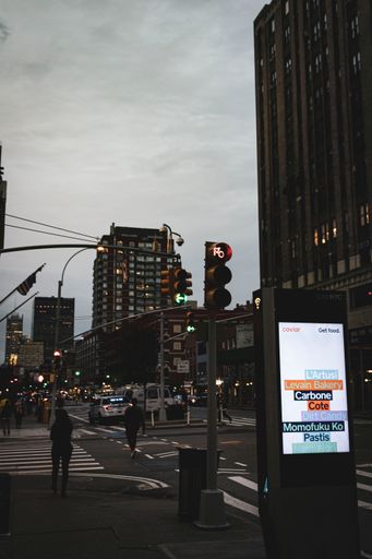 A vertical shot of a busy street against the cloudy sky in New York city