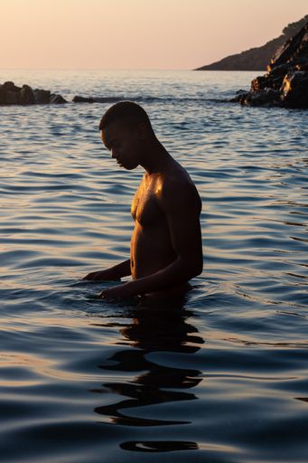 Man from Cuba into the water during the sunrise.  Some picks with a blue and yellow tones
