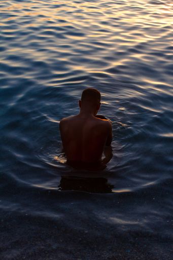 Man from Cuba into the water during the sunrise.  Some picks with a blue and yellow tones