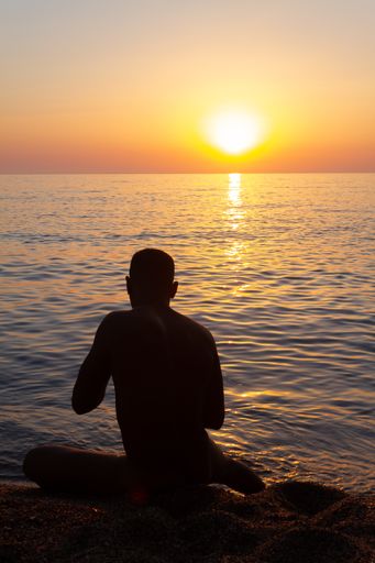 Man from Cuba into the water during the sunrise.  Some picks with a blue and yellow tones
