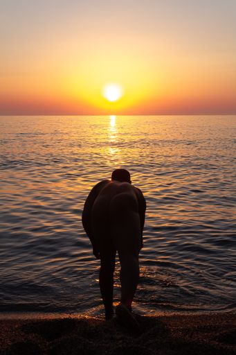 Man from Cuba into the water during the sunrise.  Some picks with a blue and yellow tones