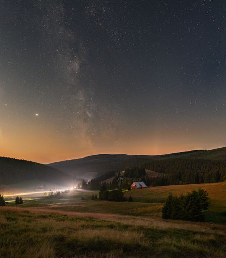 A vertical shot of a starry night sky with the Milky Way over the Giant Mountains in the Czech Republic