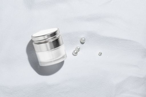 A top view of an elegant skincare container isolated on a white background with pearls