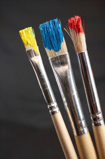 An Artist paint brushes with yellow, red, blue colors