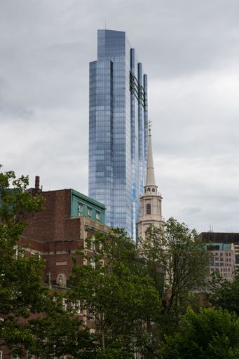 A low-angle shot of a church and skyscraper in Boston.