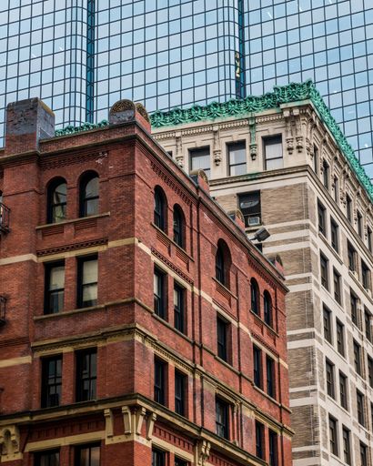 A vertical shot of old brick buildings against modern glass skyscrapers in Boston