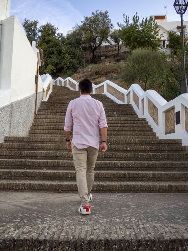 A young man climbing the stairs under the blue sky