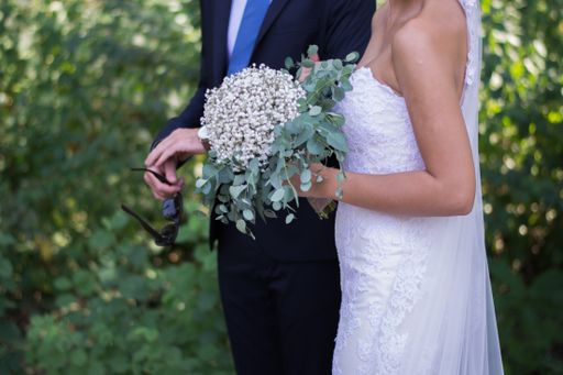 The bride and the groom with a bridal bouquet at their wedding ceremony