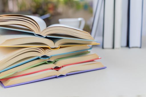 A selective focus shot of open books on top of each other