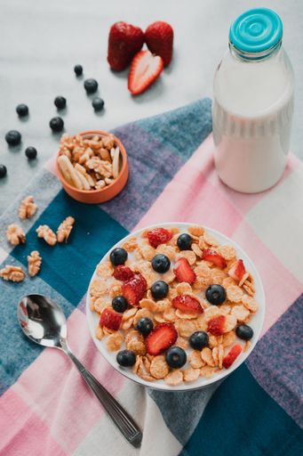 A selective focus shot of a bowl of delicious cereals with milk and berries