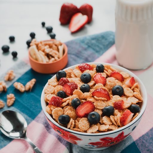 A selective focus shot of a bowl of delicious cereals with milk and berries