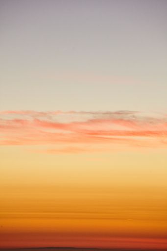 A vertical shot of the golden sunset sky over the Pacific Ocean - perfect for a background wallpaper