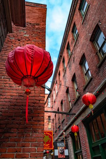A vertical low angle shot of Chinese lanterns in Fan Tan Alley, Chinatown, Victoria, BC Canada