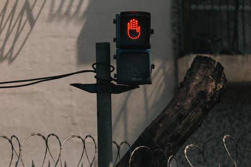 A red hand stop signal on a traffic light
