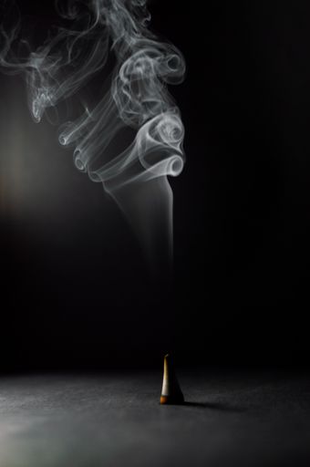 A beautiful shot of rising smoke in a dancing pattern on a dark background