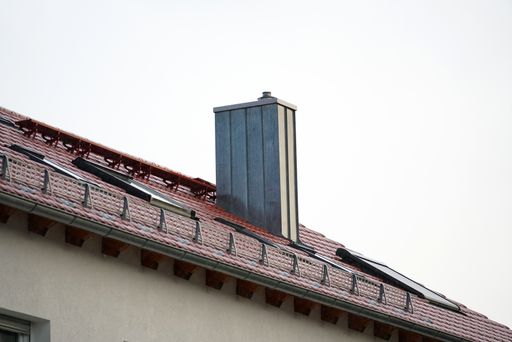 A low angle shot of a building with a concrete tile roof under the sunlight